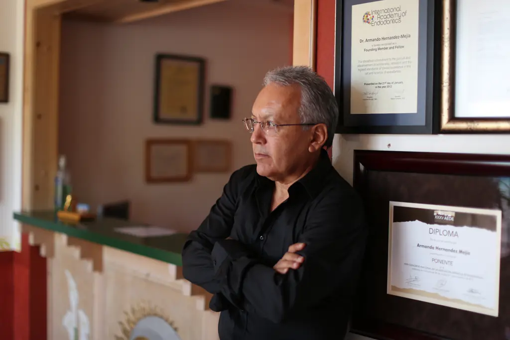 Dr. Hernández Mejía in his office next to his International Academy of Endodontics certificate